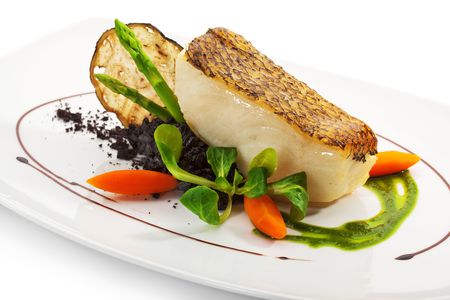 Chile Sea Bass (black sea bass) served with Black Risotto, Herbs and Vegetablesの写真素材
