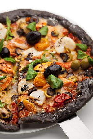 Black Ink Dough Pizza with Seafood, Black and Green Olives, Dried Tomato and Salad Leavesの写真素材