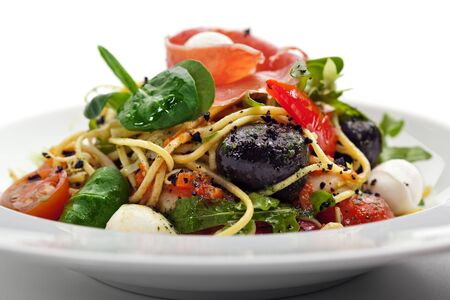 Spaghetti with Vegetables, Ham, Black Olives, Rucola and Pesto Sauceの写真素材