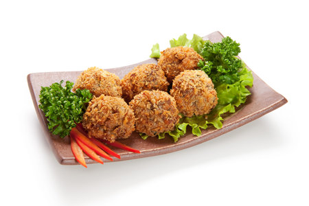 Deep Fried Salmon Croquette. Garnished on Salad Leaf with Bell Pepper and Parsley