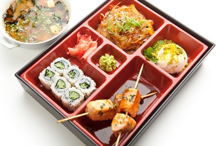 Japanese Meal in a Box  Bento  - Salad, Skewered Salmon and Sushi Roll and Dessertの写真素材