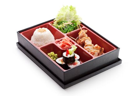 Japanese Meal in a Box (Bento) - Chuka Salad, Skewered Meat with Rice and Sushi Rollの写真素材