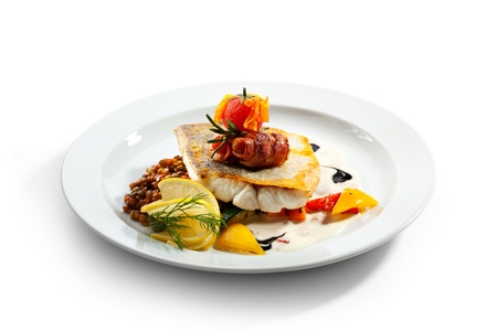Fried Fish (Zander) with Bacon. Garnished with Lemon,  Lentil and Vegetablesの写真素材