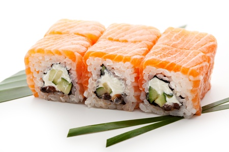Roll with Cream Cheese, Salmon roe (ikura) and Cucumber inside. Salmon and outside. Served on Salad Leafの写真素材