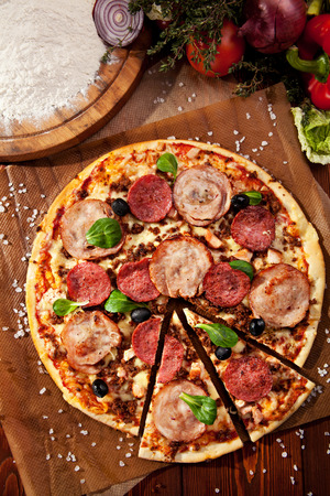 Pizza with Ham and Salami. Garnished with Olivesの写真素材