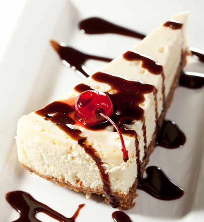 Cheesecake with Chocolate Sauce and Cherriesの写真素材