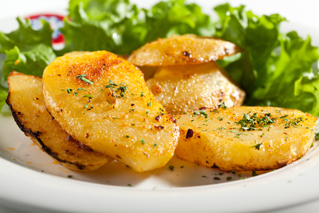 Fried Potato Garnished on Salad Leaf with Herbsの写真素材