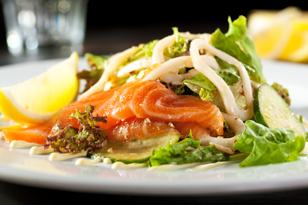 Salad with Sliced Salmon and Cucumbers. Garnished with Lemon Sliceの写真素材