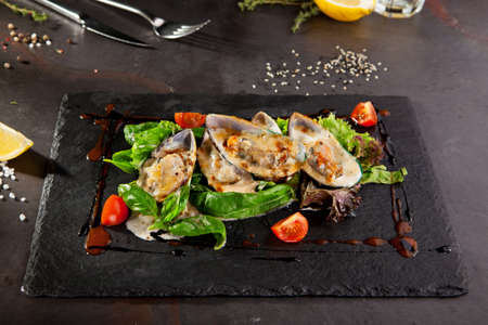 Baked Mussels with Spicy Sauce. Garnished with Cherry Tomato and Salad Leavesの写真素材