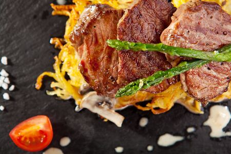 Grilled Beef Steak with Potato and Mushrooms. Garnished with Cherry Tomatoes and Asparagusの写真素材