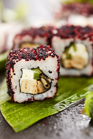 Maki Sushi - Roll made of Cream Cheese, Tamago, Cucumber and Smoked Eel inside. Red and Black Tobiko outsideの写真素材