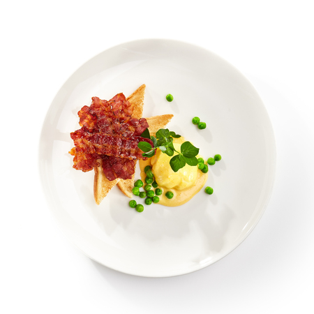 Traditional Breakfast - Eggs Benedict  with Delicious Buttery Hollandaise Sauce. Eggs Served with Fried Toast Bread and Baconの写真素材