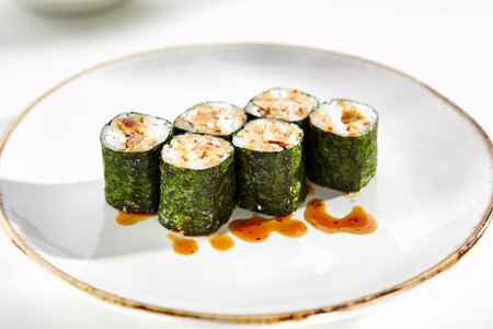 Maki rolls with tamagoyaki served on white flat plate. Asian menu for gourmets in luxury restaurantの写真素材