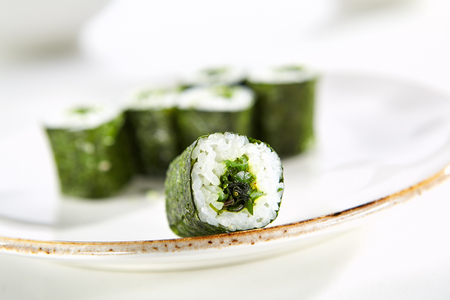 Maki rolls with seaweed with Hiashi wakame served on white flat plate. Asian menu for gourmets in luxury restaurantの写真素材
