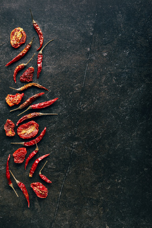 Food Minimal - Chili pepper and dried tomatoes on black slate background. Flat Layの写真素材