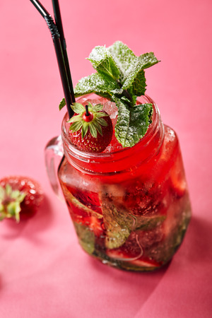 Cocktail - strawberry mojito with mint and lime and ice in glass gobletの写真素材