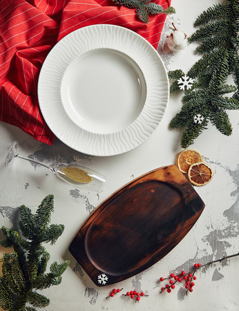 Vintage New Year Background with Empty Plate, Traditional Winter Spices, Herbs and Natural Cotton Branch on Gray Plaster Texture Top View. Retro Christmas Table with Place for Text or Copyspaceの写真素材