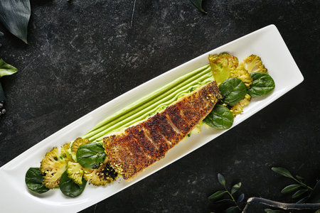 Beautiful Restaurant Plate of Baked Halibut Fillet and Broccoli in Different Textures Top View....