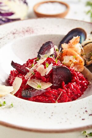 Macro shot of red beetroot risotto with shrimps, prawns, mussels and Parmesan cheese.の写真素材