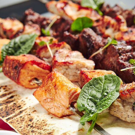 Chicken, Salmon and Meat Shish Kebabs on Parchment with Saucesの写真素材