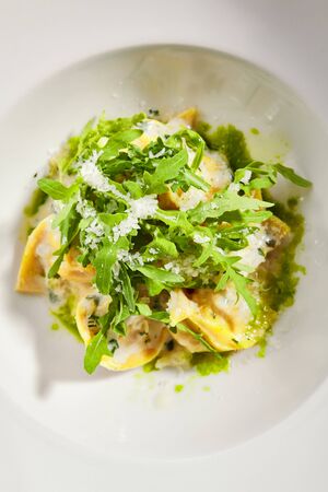 Tortellini with rabbit meat pesto sauce and arugula top view.の写真素材