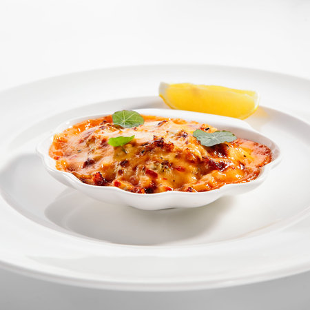 Seafood lasagna portion closeup. Italian traditional cuisine. Layered baked meal isolated on white...