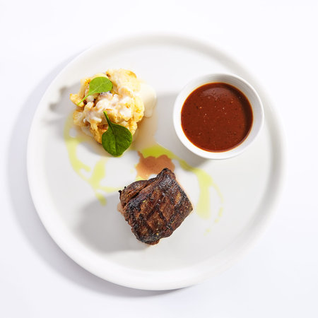 Filet mignon steak with cauliflower dish top view. Baked beef with peppercorn sauce. Roasted meat...