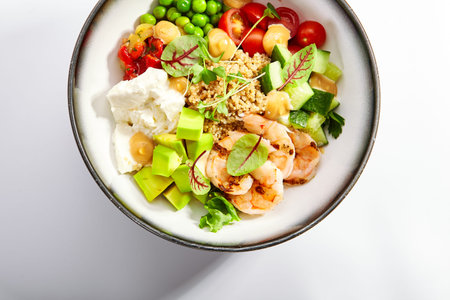Bowl of couscous with shrimp and vegetables. Tasty meal with tofu cheese and seafood top view....