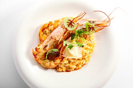 Risotto tom yam with argentinian shrimp. Delicious thai dish with seafood closeup view. Traditional asian meal with rice and aromatic greenery. Food composition on white plate. Restaurant delicacyの写真素材