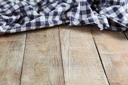Old wooden wooden table with blue napkin on background. Rustic desk side view.の写真素材