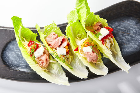 Romano lettuce with roast beef and celery remoulade. Delicious snacks with meat and greenery. Tasty served meal with cheese top view. Restaurant food on wooden tray. Culinary presentationの写真素材