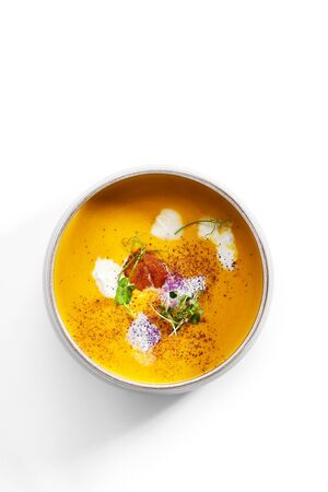 Pumpkin soup in bowl. Served main course. Vegetable cream soup with Italian stracciatella cheese. Restaurant food decorated with herbs composition. Dinner, gourmet meal in plateの写真素材