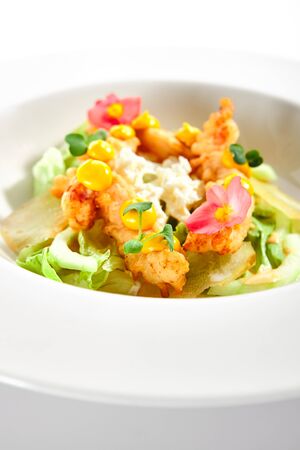 Warm salad with crispy langoustines. Delicious served dish with roasted seafood. Tasty food in white plate decorated with flowers and sauce. Haute cuisine, sicilian recipe. Restaurant menuの写真素材