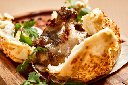 Chicken in dough served on wooden tray. Baked poultry in bread bun top view. Luxury restaurant food...
