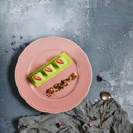 Tropical mousse desserts flat lay. Sweet candies and gourmet cakes served on luxury plates and handmade saucers top view. Confectionery desserts decorated with caramel smears, fresh fruits and petalsの写真素材