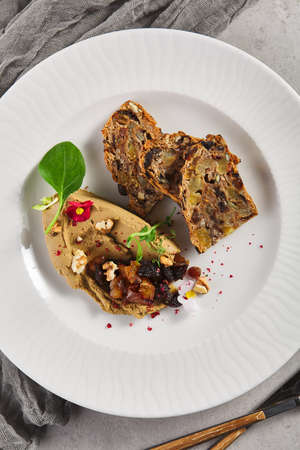 Pate with Dried Fruits and Nuts Bread. Gray table with textile and kitchenware. Rustic food styleの写真素材