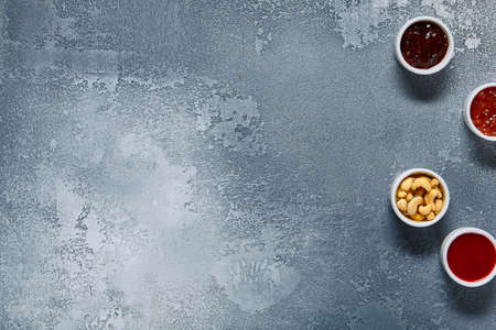 Jam and sweet nuts on blue textured background. raditional morning dip. Sweet food.の写真素材