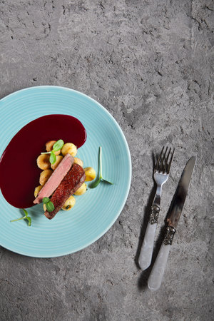 Duck Breast with Berry Sauce and Baby Potato. Blue Plate and Microgreensの写真素材