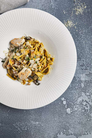 Gourmet Pasta with Chicken and Mushrooms. Vintage dark blue table.の写真素材