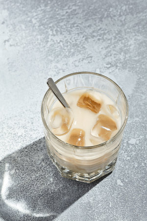 White russian cocktail is a cocktail made from coffee liqueur and vodka. Cocktail glass with spoon...