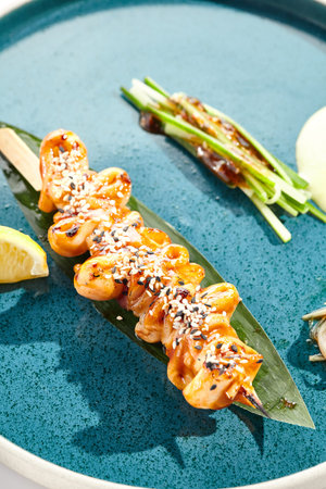 Japanese bbq - skewer yakitori with squid and teriyaki sauce. Grilled calamari on bamboo stick in Japanese style. Bbq menu for asian restaurant. Yakitori on white backgroundの写真素材