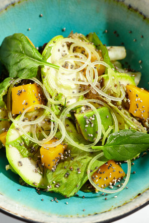 Fresh healthy food - green salad with avocado, mango. Vegetarian dish for restaurant on white...