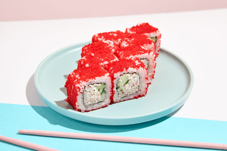 California maki roll with tobiko caviar on modern colored background. Sushi roll with crab and...