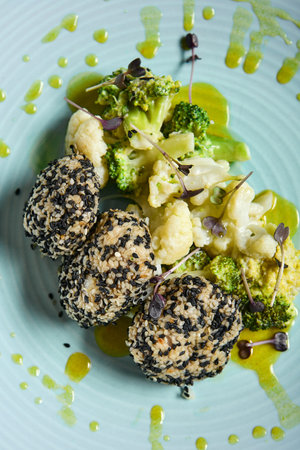 Fish cutlets in sesame seeds with broccoli and cauliflower. Keto menu for restaurants. Fishcake with...
