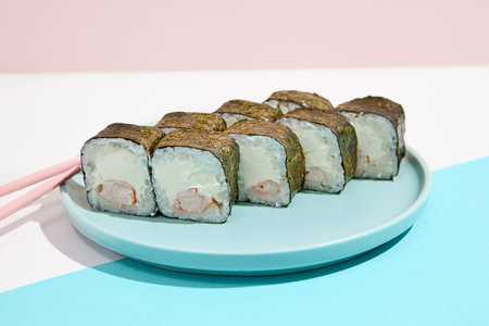 Simple cheese maki roll with shrimp on ceramic plate. Shrimp hosomaki in minimal style on colored background. Japanese menu concept. Sushi roll with fresh and cheese. Maki sushi wallpaperの写真素材