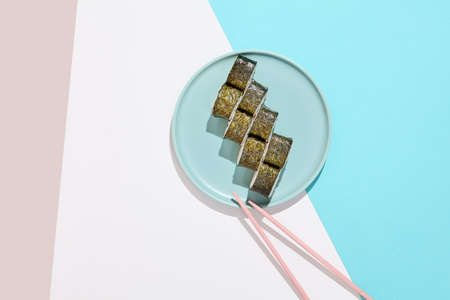 Simple cheese maki roll with shrimp on ceramic plate. Shrimp hosomaki in minimal style on colored background. Japanese menu concept. Sushi roll with fresh and cheese. Maki sushi wallpaperの写真素材