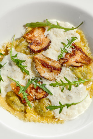 Mushroom ravioli and cheese sauce isolated on white background. Italian dish - ravioli with porcini...