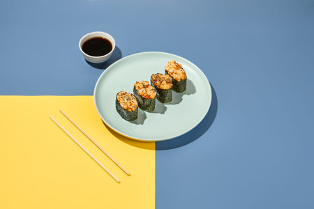 Gunkan sushi set in plate on colored background with chopsticks and soy sauce. Minimal composition...