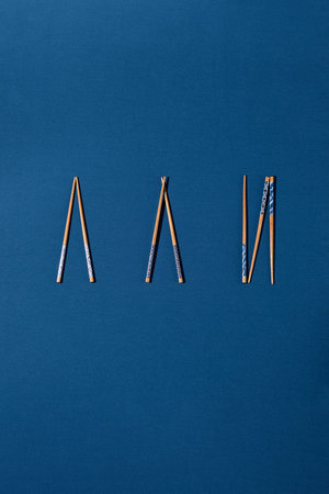 Overhead view of Asian chopsticks set against a vibrant blue background.の写真素材