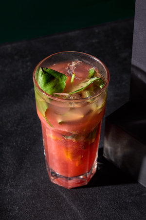 Chilled strawberry and basil lemonade presented elegantly against a contrasting black background.の写真素材